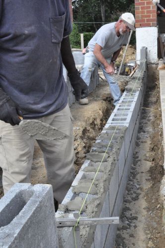 two men are working on the foundation of a house