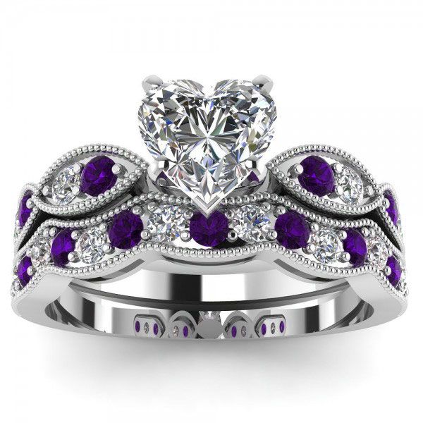 Capture her heart with this sweet ring set. Beautifully crafted in sterling silver, this entrancing design features a shimmering heart cut stone at the center and alternating purple and white stones arranged between intricate milgrain borders. On your wedding day, seal your vows and celebrate your commitment with the coordinating wedding band. A great anytime choice, this ring set is sure to become an instant favorite. Carat Weight: 3.065 ctStone Size: 8*8 mmStone Type: Jeulia® StoneNumber of Stones: 1 Stone Color: Diamond WhiteStone Shape: HeartCarat Weight: 2.28 ctStone Size: 2 mmStone Type: Jeulia® StoneNumber of Stones: 27 Stone Color: Diamond White, Amethyst PurpleStone Shape: RoundWeight: 6 gWidth: 10.9 mmHeight: 7.4 mmThickness: 4.9 mmMaterial: 925 SilverPlating Color: Silver White Sapphire Wedding Set, Sapphire Wedding Set, Womens Wedding Ring Sets, Blue Wedding Rings, Ruby Wedding Rings, Sterling Silver Rings Set, Silver Ring Set, Purple Jewelry, Bridesmaid Jewelry Sets