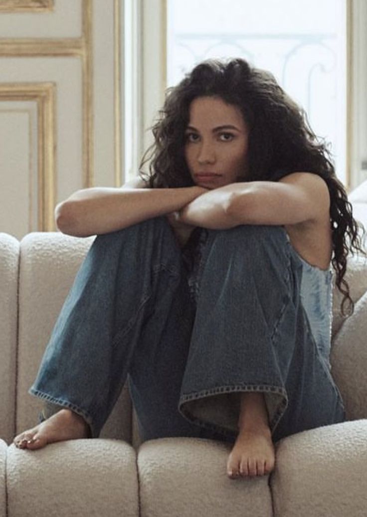 a woman sitting on top of a white couch