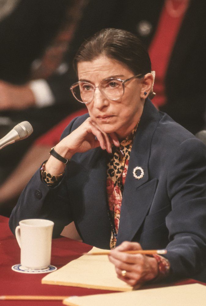 a woman sitting at a table in front of a microphone