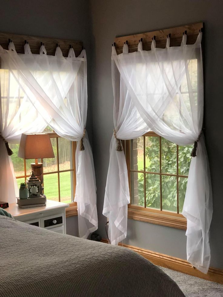 two windows with sheer curtains in a bedroom