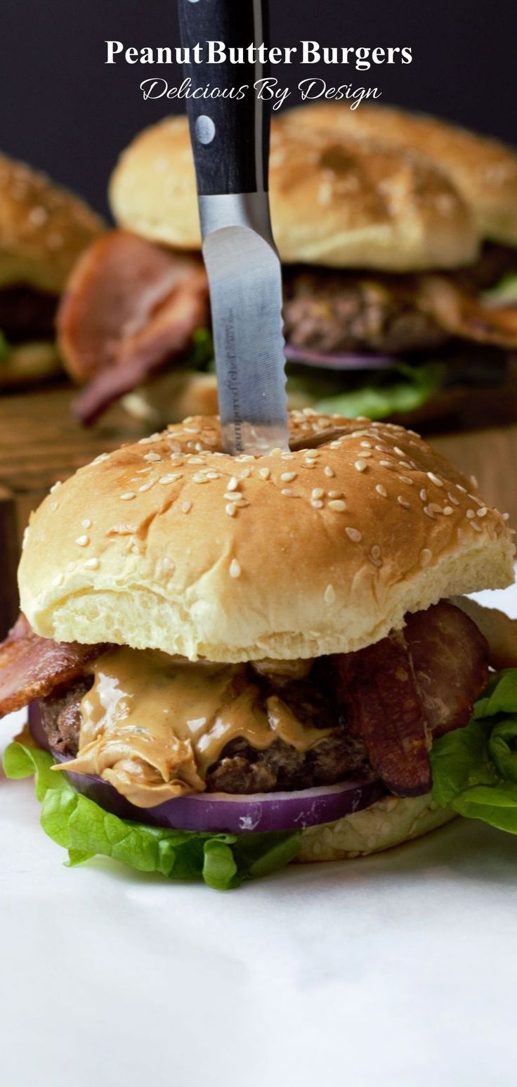 a sandwich with bacon, lettuce and cheese is being cut by a knife