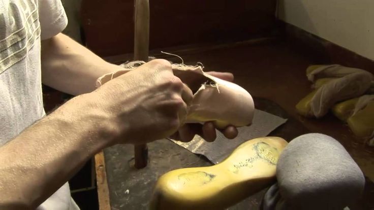 a man is working on some shoes in the room with his feet propped up next to him