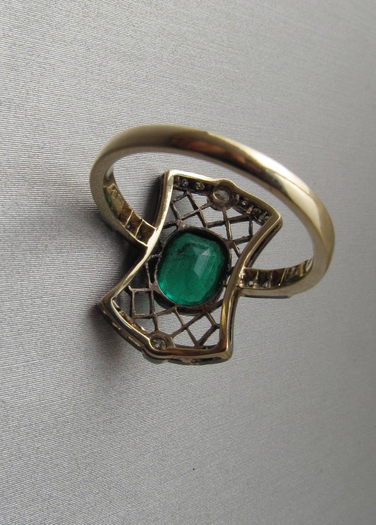 Art Deco emerald ring with diamonds, made of 14K gold and silver. With a Hungarian 14K hallmark that was used after 2016. The top part is made of silver. The head part of the ring is 0.796 inches (20 mm) long. Gemstone: one piece of emerald, 1.54 carat, its size is: 0.24 inches * 0.31 inches (6.1 mm * 7.8 mm) The emerald has inclusions which unfortunately affects the surface of the stone as well. I tried to make photos of that. Additional gemstone details: 20 single cut diamonds Carat weight: 0. Art Deco Emerald Ring With Rose Cut Diamonds, Art Deco Green Emerald Ring With Rose Cut Diamonds, Art Deco Emerald Ring With 17 Jewels For Anniversary, Victorian Emerald Ring In Yellow Gold Stamped 14k, Victorian Emerald Ring In 14k Yellow Gold, Antique Emerald Ring In Stamped 14k Yellow Gold, Art Deco Emerald Jewelry With Rose Cut Diamonds, Antique Green Emerald Cut Ring, Antique Green Emerald Cut Emerald Ring