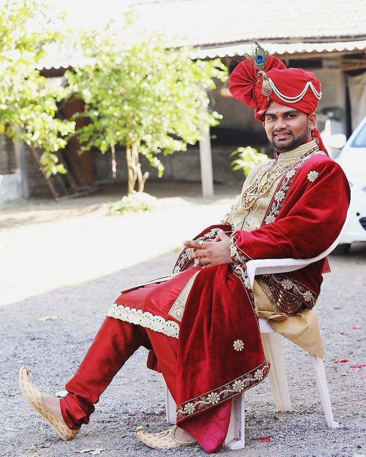 a man in a red and gold outfit sitting on a white chair