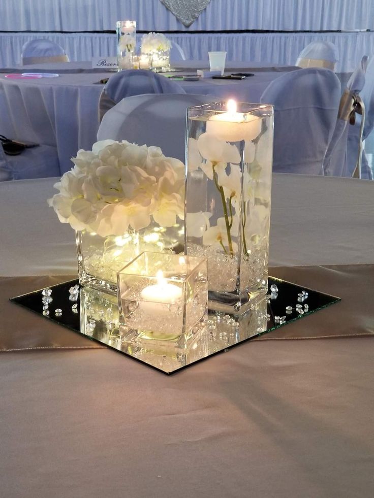 some candles are sitting on a table with flowers