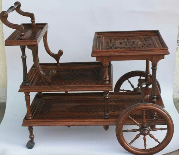 an old fashioned wooden cart with wheels on it's sides and a small table in the middle