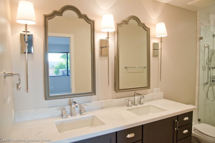 a bathroom with two sinks, a toilet and a shower stall in it's corner