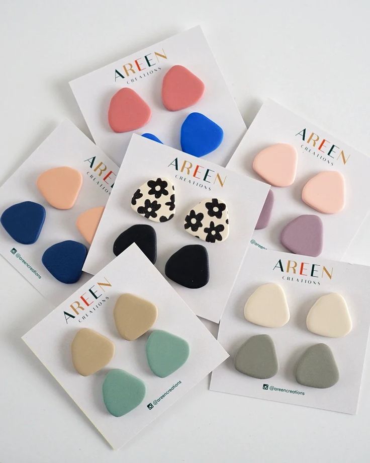 four pairs of heart shaped earrings on top of each other in different colors and shapes