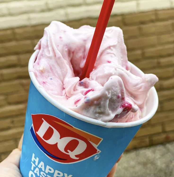 a person holding up a ice cream sundae with sprinkles