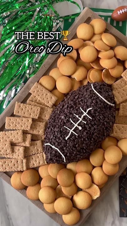 a football themed cheese board with crackers and pretzels in the shape of a football