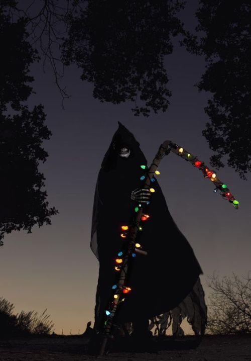 a person dressed as a ghost with lights in their hands, holding a stick and looking up at the sky