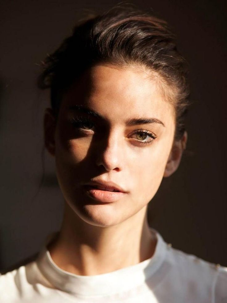 a close up of a person wearing a white t - shirt and black eyeliners