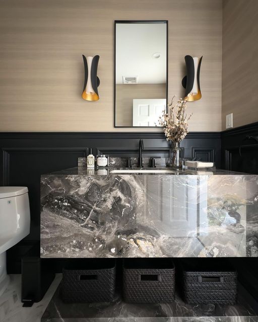 a bathroom with marble counter tops and black cabinets, along with two mirrors on the wall