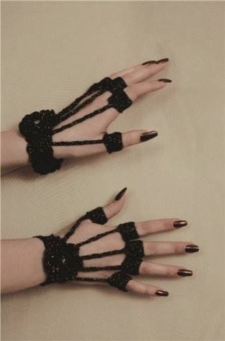 two hands with black nail polish and lace on them, one holding the other's hand