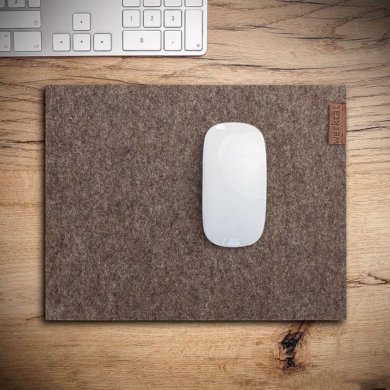 a mouse pad sitting on top of a wooden desk next to a keyboard and computer mouse