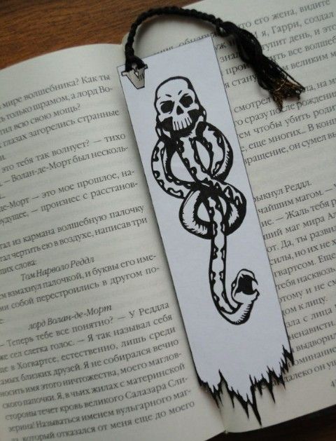 a bookmark with an image of a snake on it and a skull in the middle