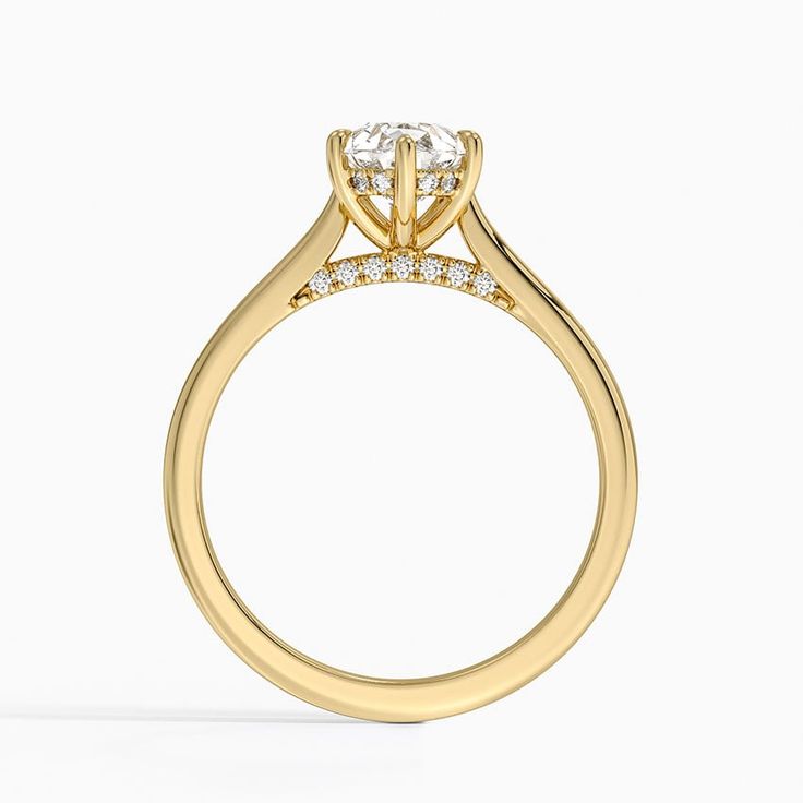 a yellow gold engagement ring with three stones on the side and an oval diamond set in the center