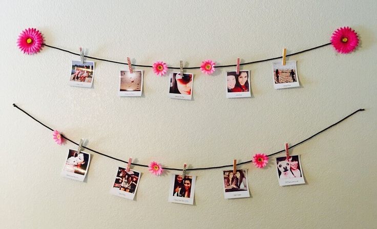 several photos hanging on a string with pink flowers