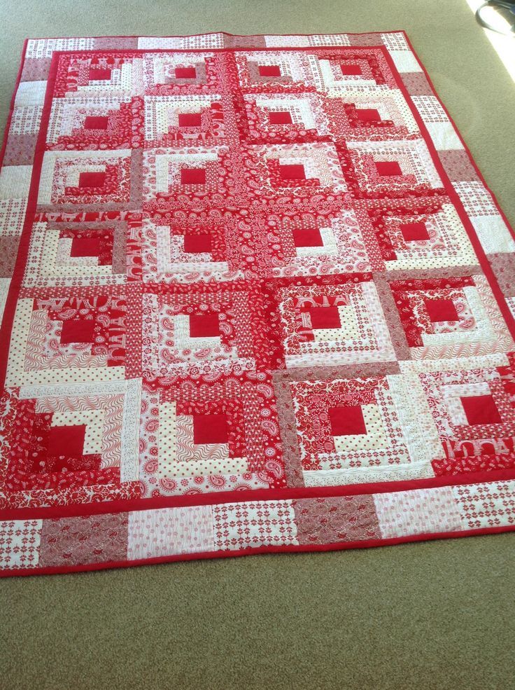 a red and white quilt is laying on the floor