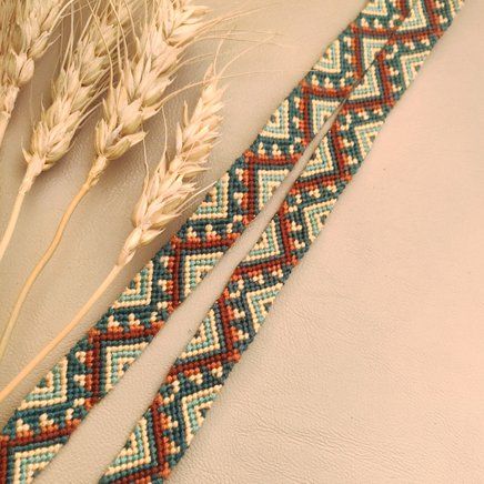 two pieces of beaded fabric next to some wheat