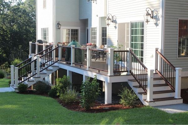 a house with a deck and stairs leading up to the front door