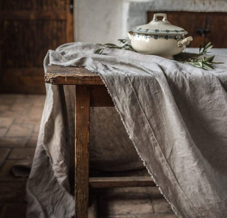 a table topped with a white bowl and cloth