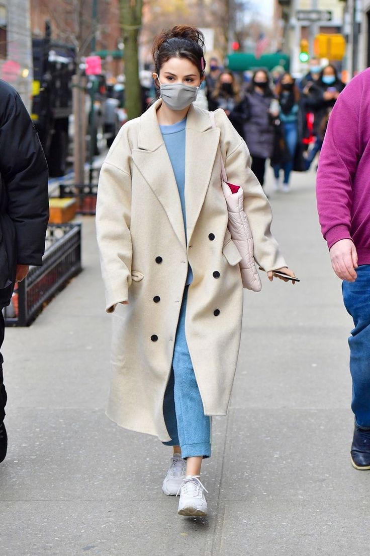 a woman wearing a face mask walking down the street