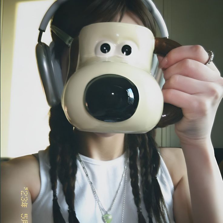 a woman wearing headphones with a dog face on it's side and long dreadlocks