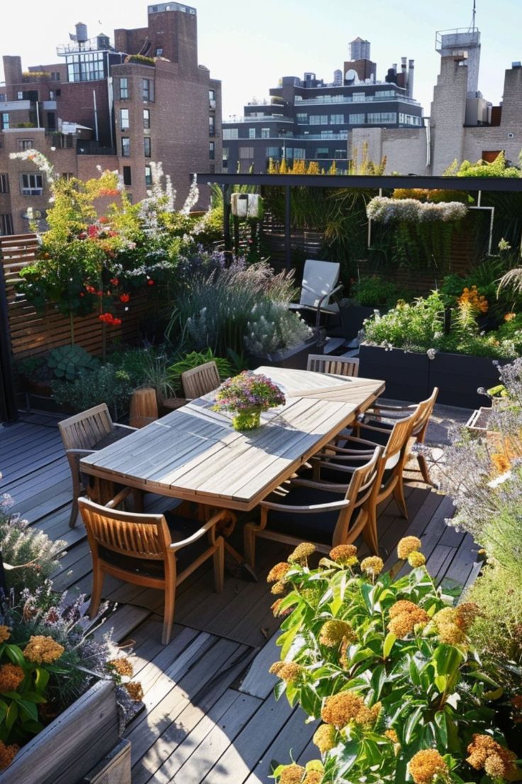 an outdoor dining table and chairs on a wooden deck surrounded by potted plants with yellow flowers in the foreground