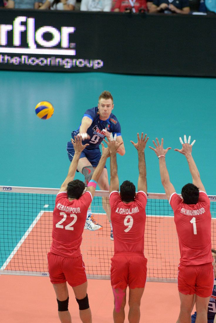 four men are playing volleyball on the court