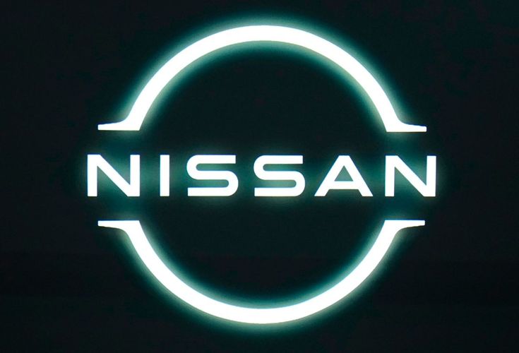 the nissan logo is lit up in green and white lights on a black background,