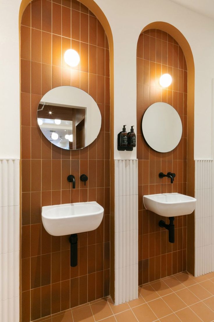 there are two sinks in the bathroom with mirrors on the wall and one is white