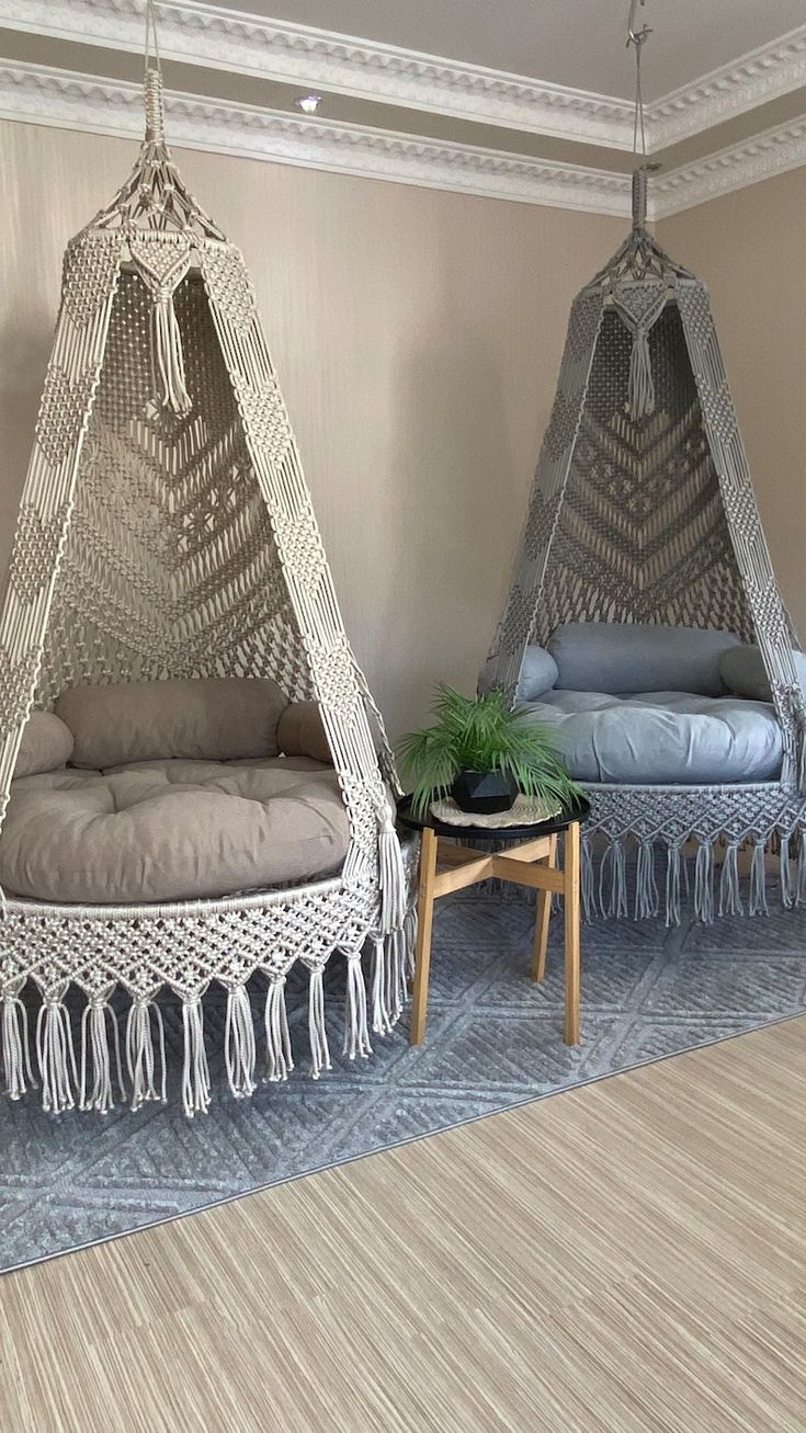 two hammocks with tassels hanging from the ceiling in a living room