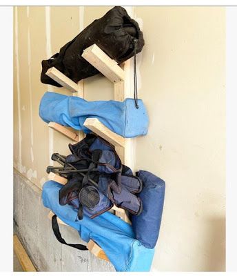 several pairs of shoes are hanging on a wooden rack in front of a wall and door