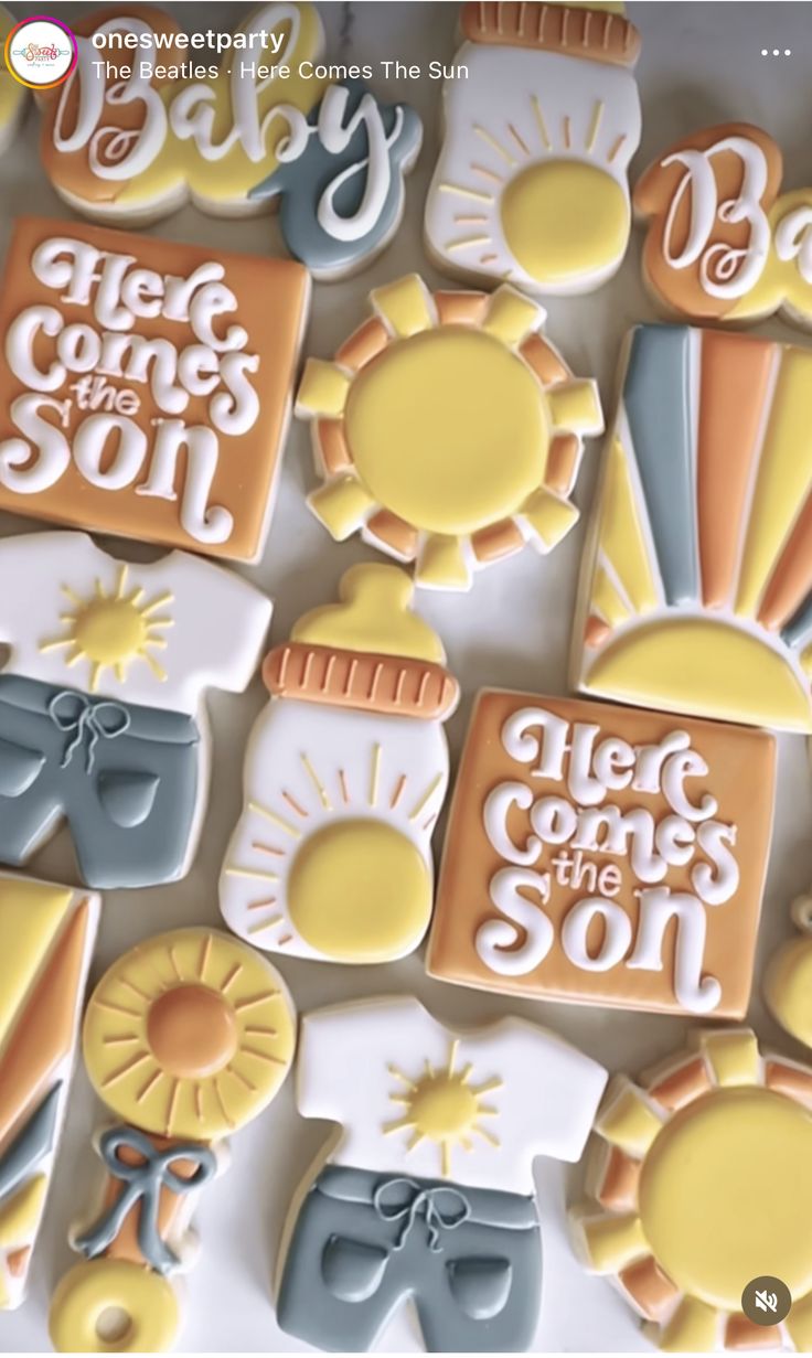 some cookies that are on top of a white tablecloth with the words hello comes the son