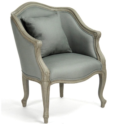 an old fashioned chair with grey fabric and silver trimmings on the armrest