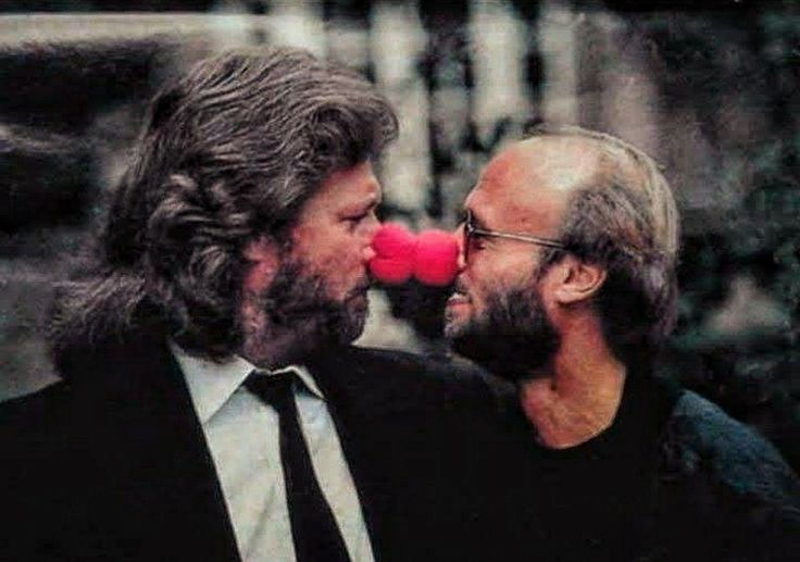 two men with long hair and beards, one is blowing the other's nose