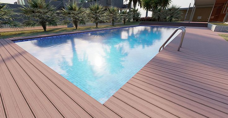 an empty swimming pool in the middle of a large building with palm trees around it