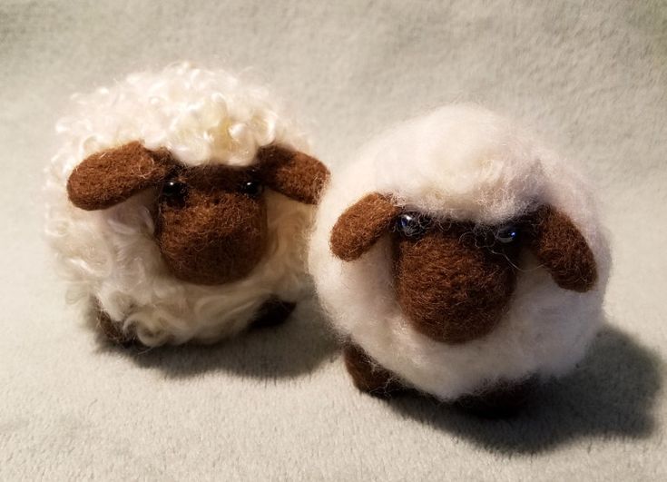 two small stuffed sheep sitting next to each other