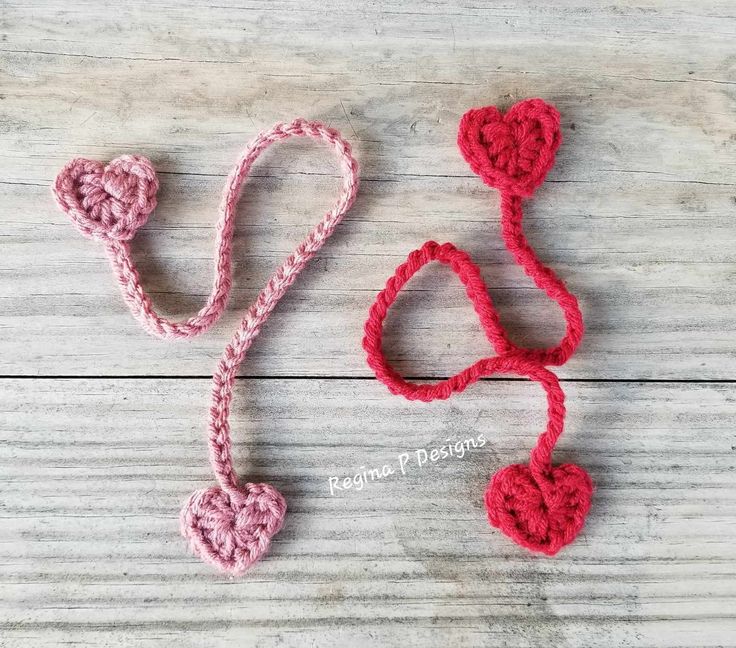 two crocheted hearts and a stethoscope on a wooden surface