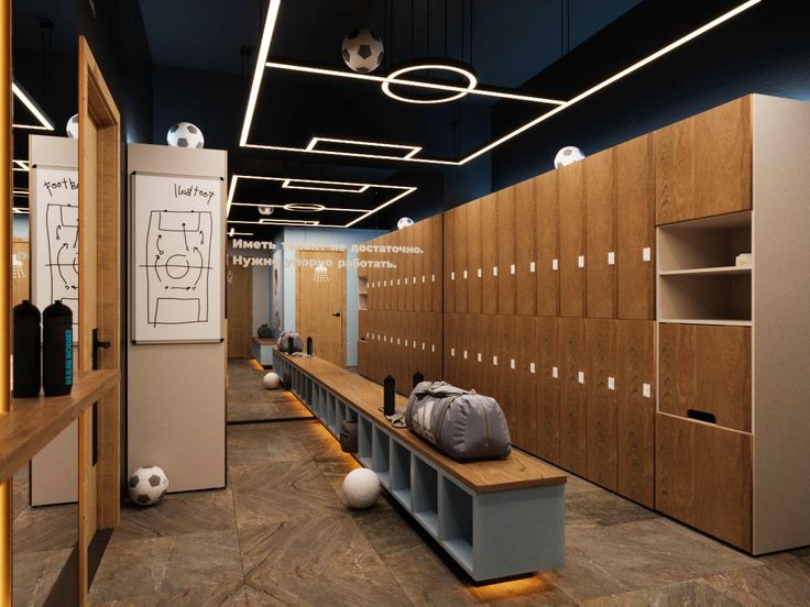 a locker room with soccer balls and backpacks on the bench in front of it