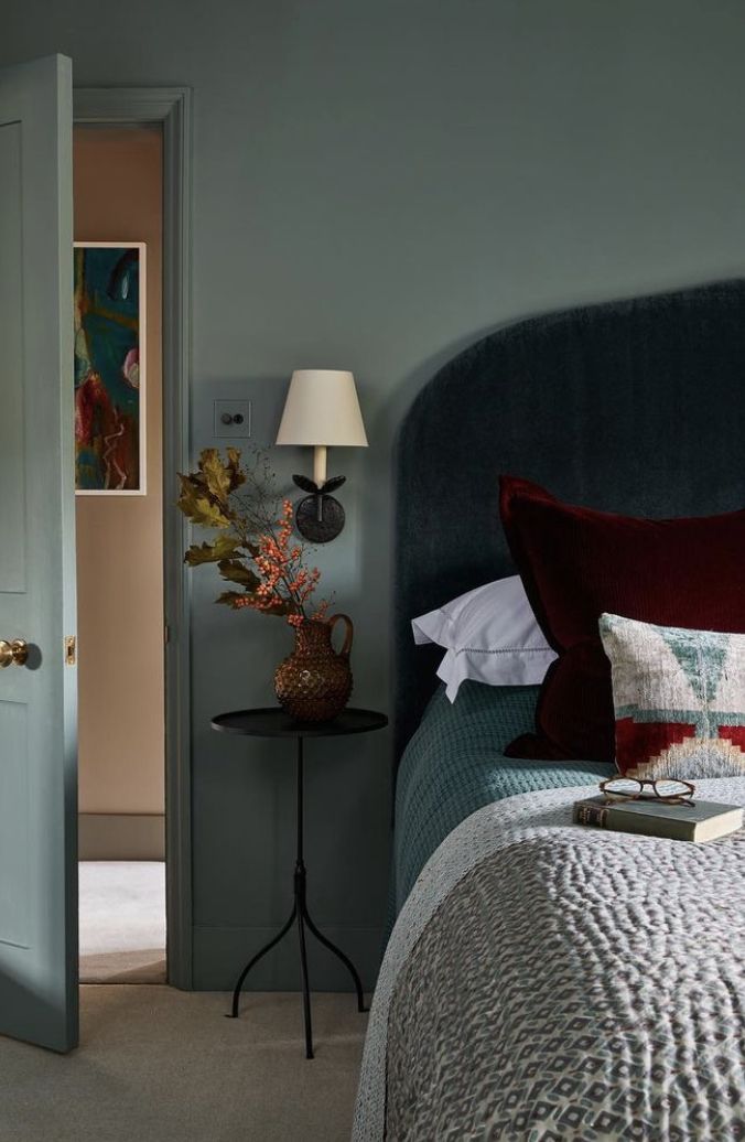 a bed sitting next to a door in a bedroom on top of a carpeted floor