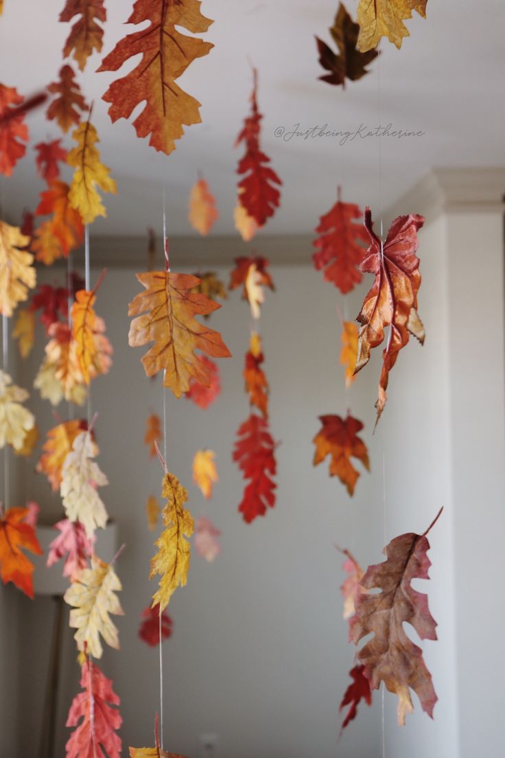 autumn leaves are hanging from the ceiling