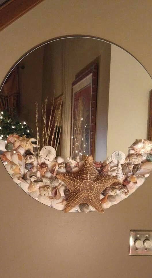 a mirror that is hanging on the wall above a starfish and seashells