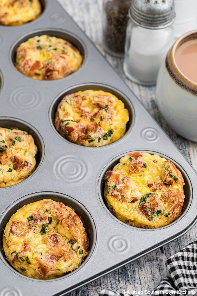 several muffins in a pan next to a cup of coffee