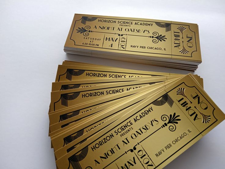 five golden tickets sitting next to each other on top of a white table with black writing