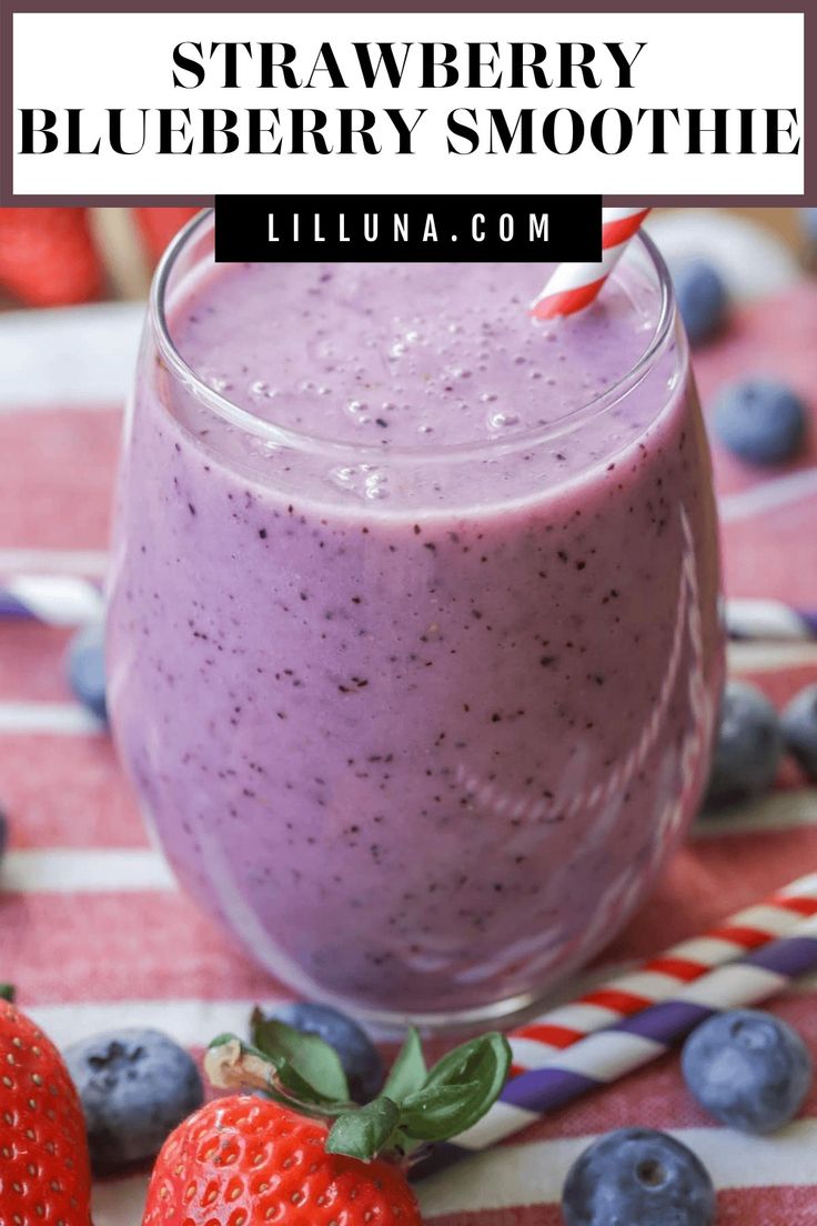 blueberry smoothie in a glass with strawberries on the side