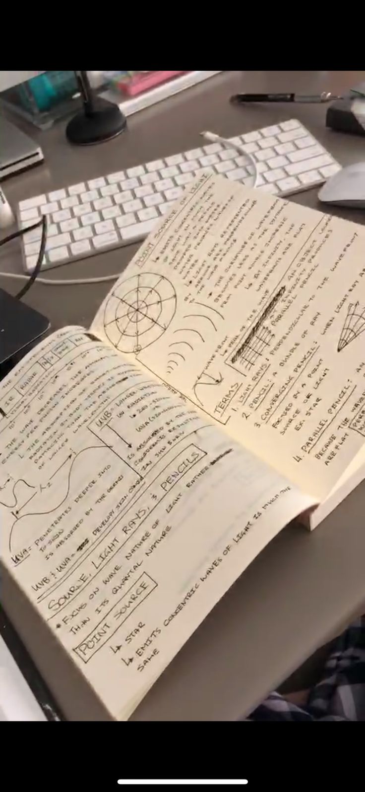 an open book sitting on top of a desk next to a keyboard