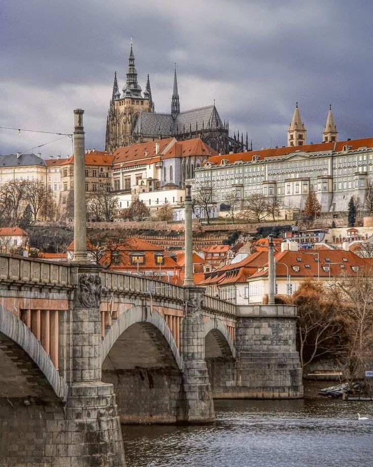 an old bridge over a river with buildings in the background